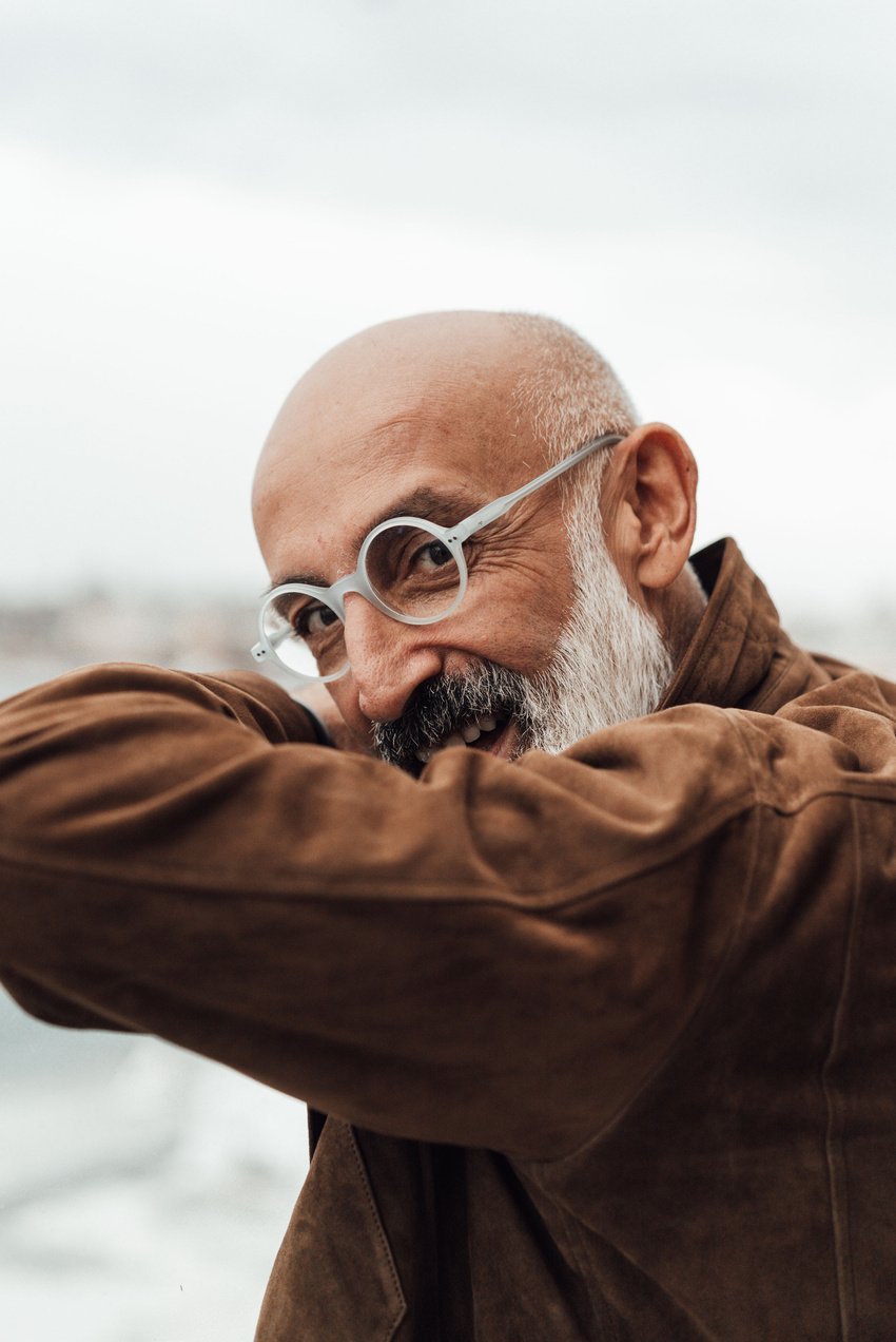 Content senior ethnic man smiling during cruise in sea on cloudy day